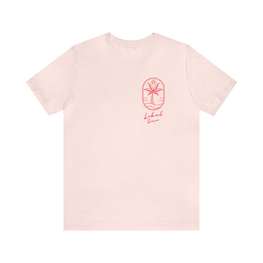 The front of Palm Tree Tee - We're All Lokals Somewhere Graphic T-shirt in soft pink 